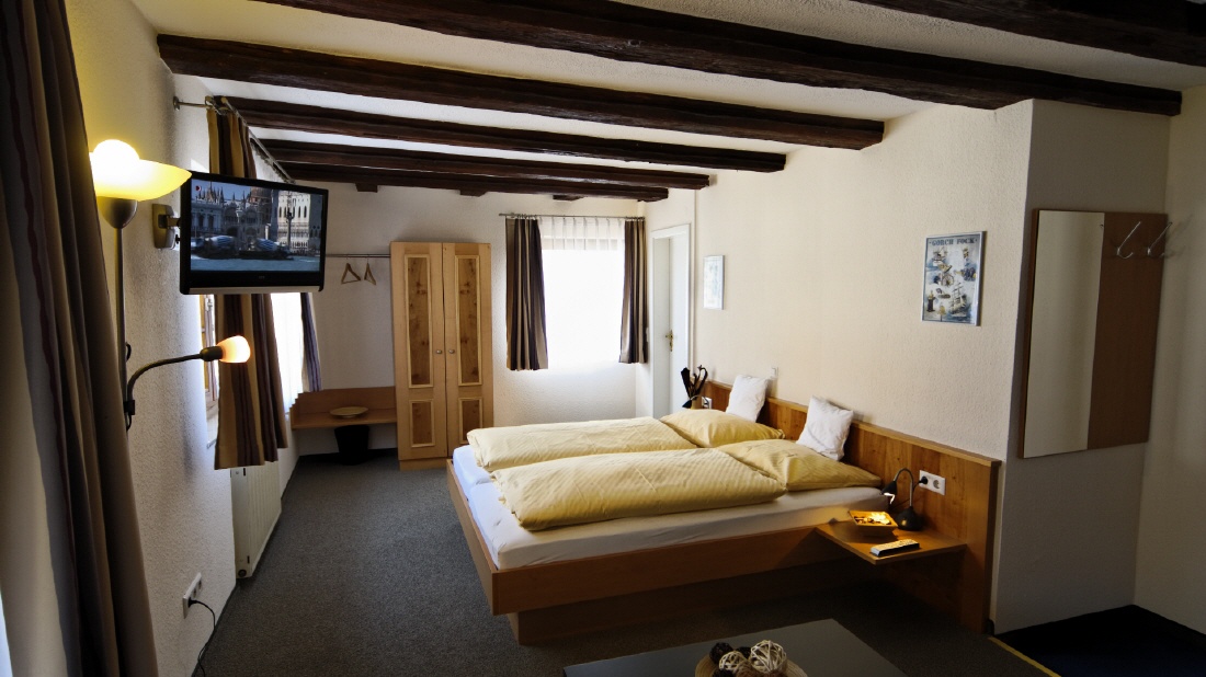 Doppelzimmer mit sichtbarem Holzgebälk und zwei Betten