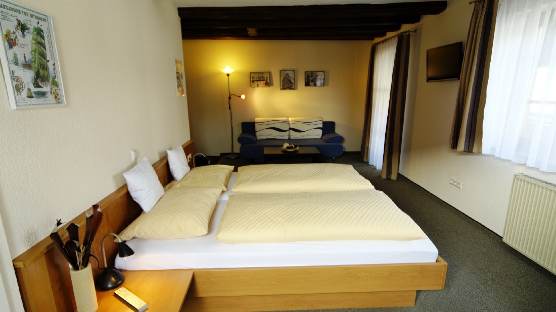 Geräumiges Zimmer mit Doppelbett und Sofaecke