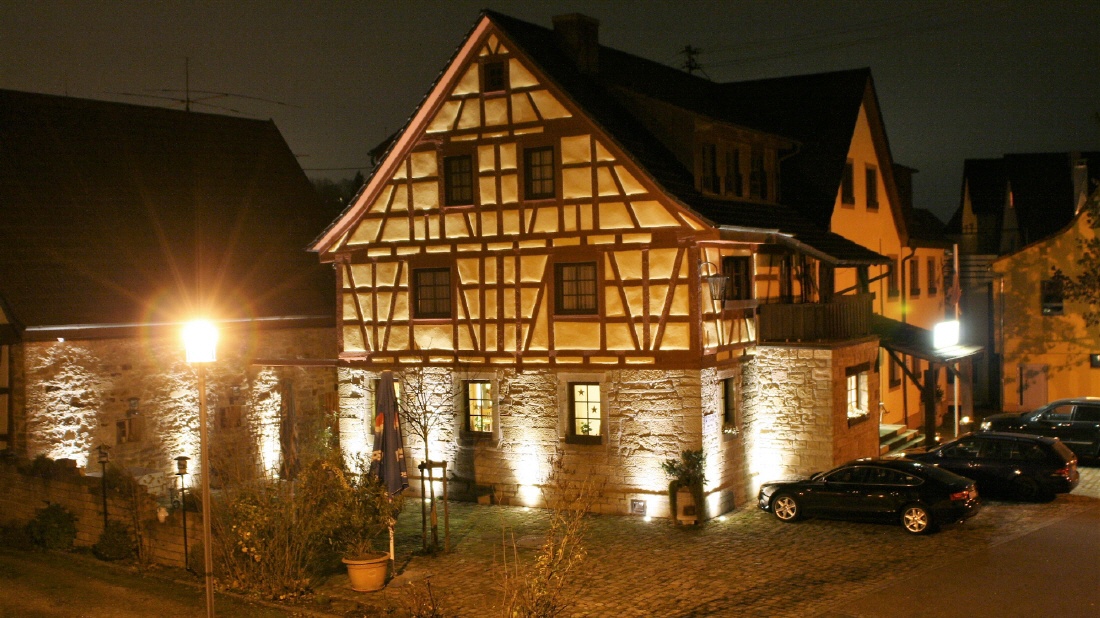 Die beleuchtete Fachwerk-Mühle des Hotels Neckarmühle bei Nacht
